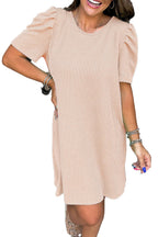 Model wearing parchment knit mini dress with ribbed texture and puff sleeves casual above knee shift silhouette