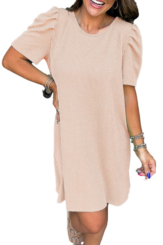 Model wearing parchment knit mini dress with ribbed texture and puff sleeves casual above knee shift silhouette