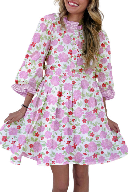 LuckeLadybug pink floral mini dress with puff sleeves ruffled collar and tiered skirt modeled against white brick wall