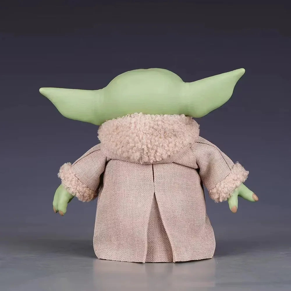 Back view of a Mandalorian action figure featuring a character with green skin and a cozy beige coat