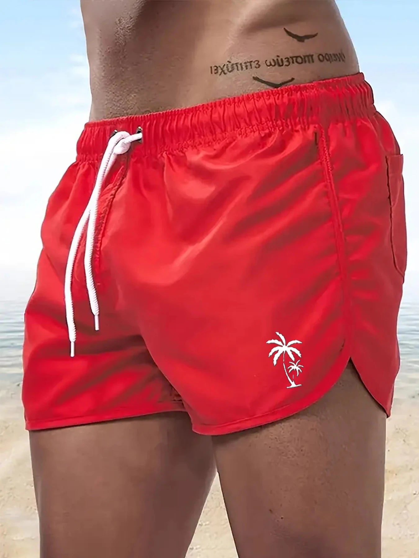 Red boardshorts for men in swim trunks featuring a palm tree logo, perfect for beach outings.