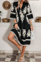 Black and white embroidered midi dress with a fit and flare design and three-quarter sleeves