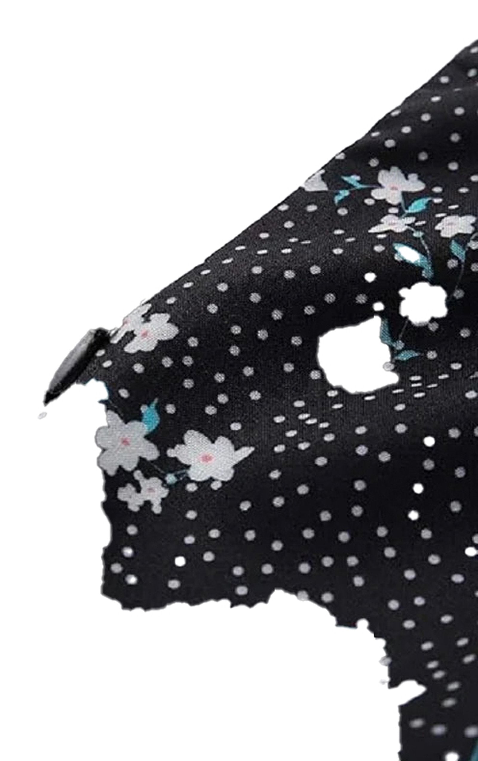 Close-up of mini floral dress for women featuring a black fabric with white polka dots and floral pattern