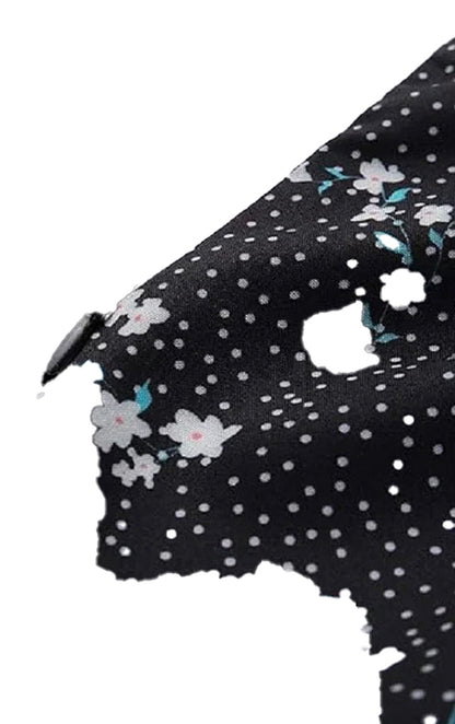 Close-up of mini floral dress for women featuring a black fabric with white polka dots and floral pattern