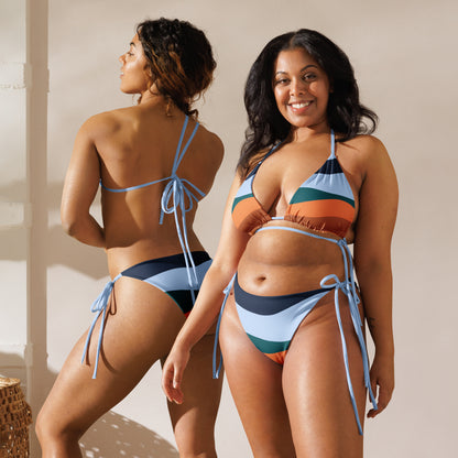 Two women wearing LuckeLadybug multi color bikini for women with blue, orange, and green stripes posing indoors