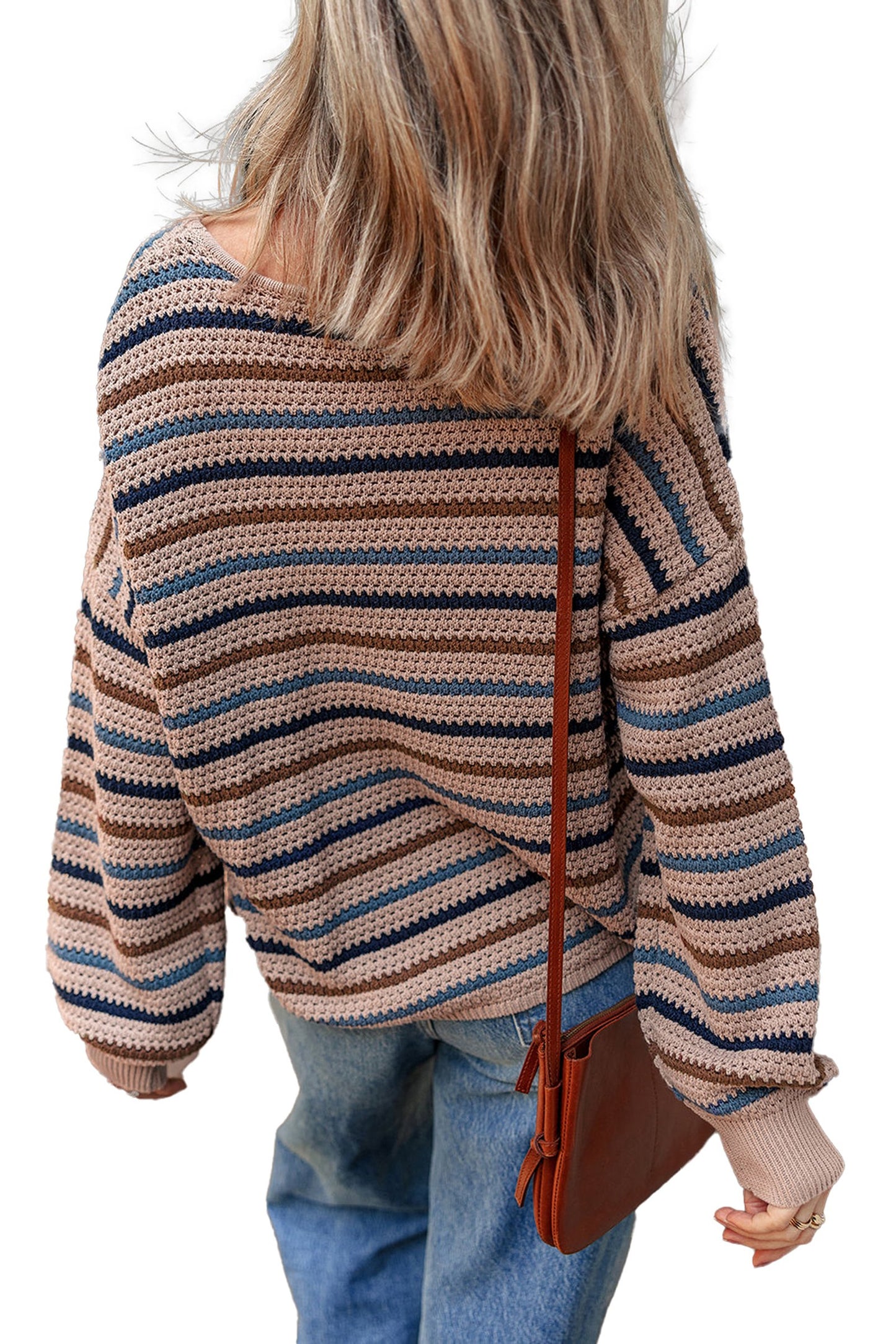 Back view of a multicolor striped knitted sweater with loose fit and wide sleeves, paired with denim jeans