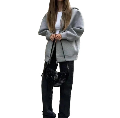 Stylish oversized zip up hoodie for women in gray, paired with black trousers and a bag