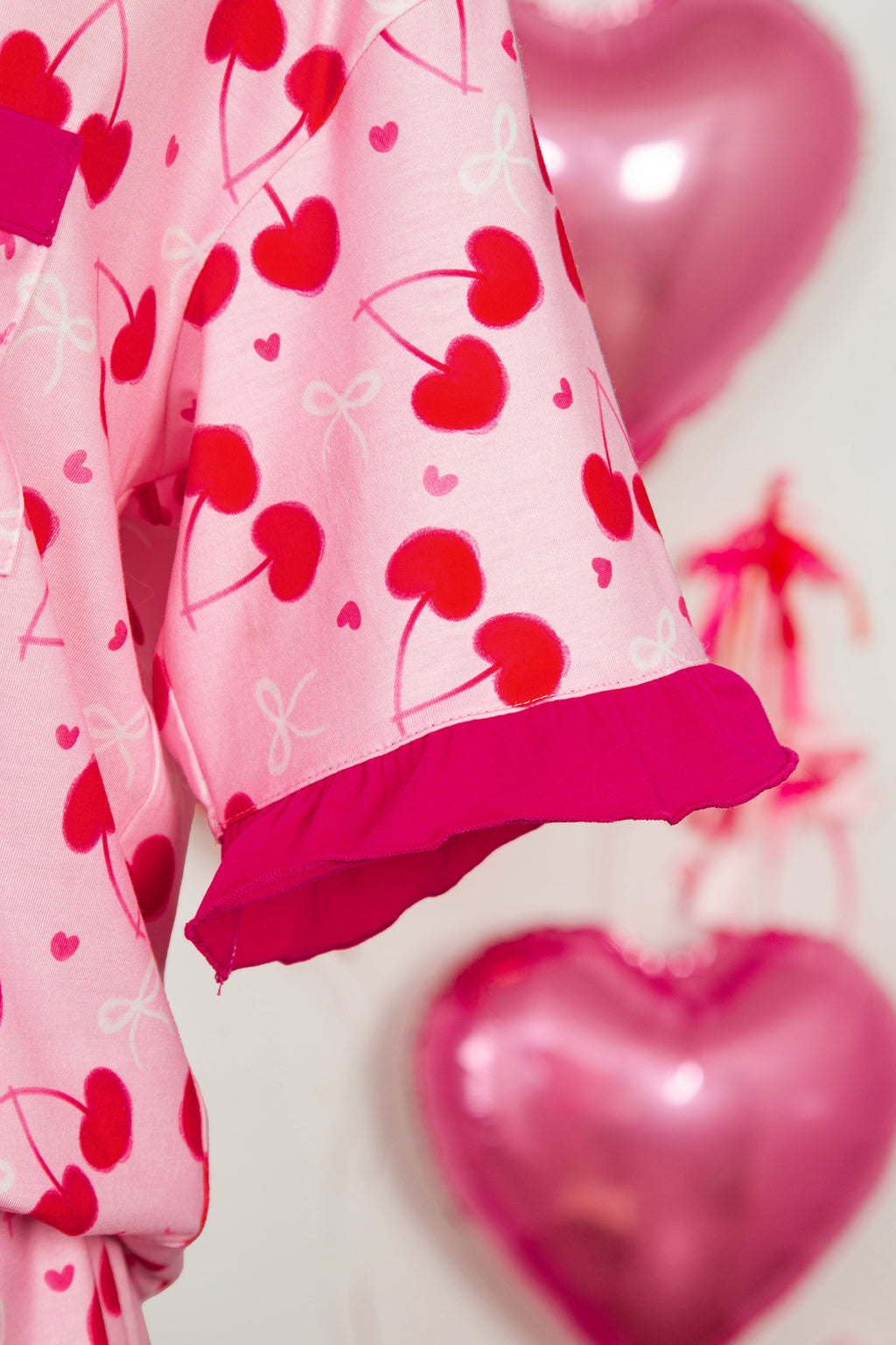 Pink LuckeLadybug LLC pajama set featuring heart and bow patterns with ruffled sleeves