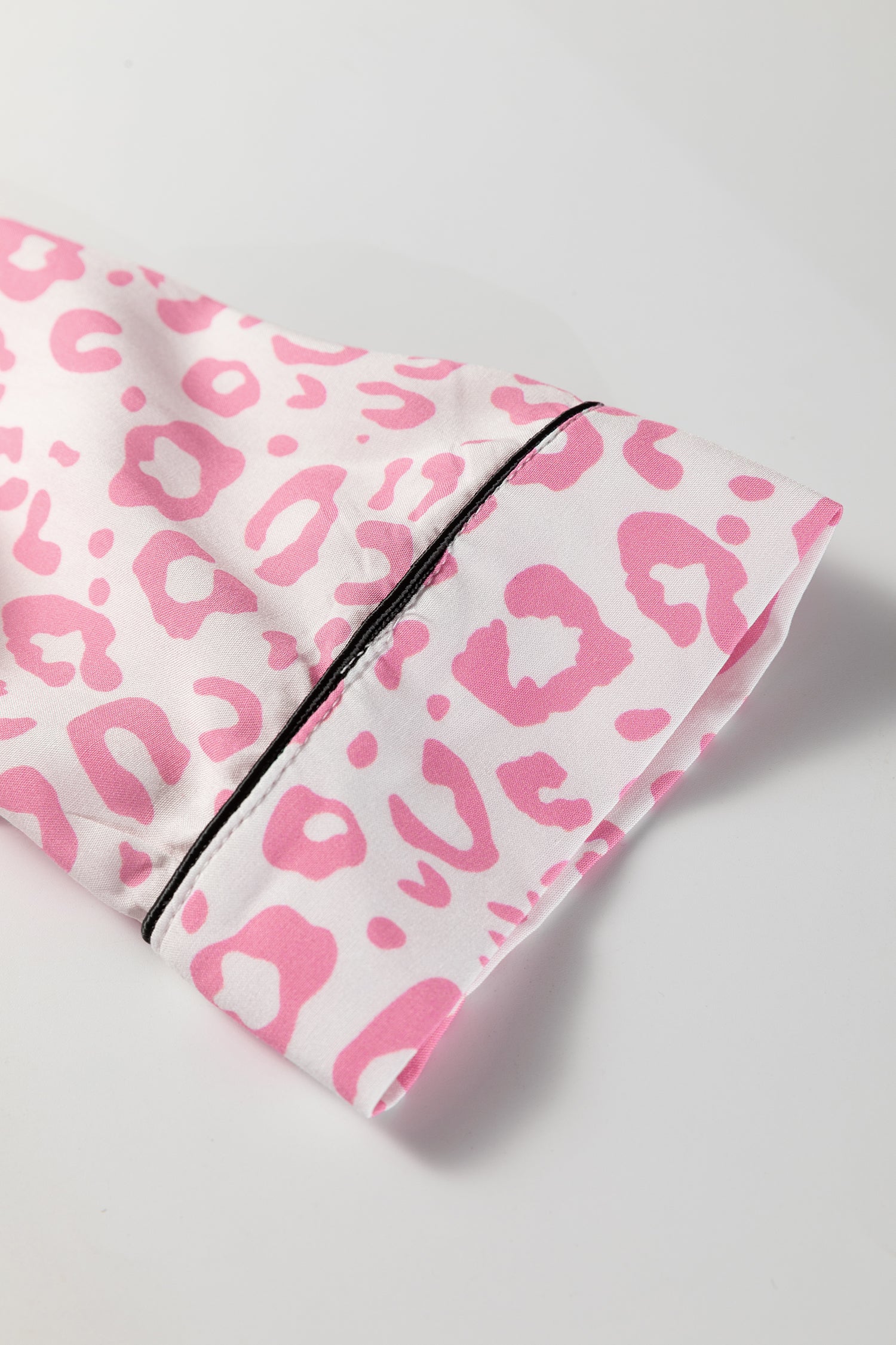 White and pink leopard print pajama set sleeve detail with black trim for comfort and style