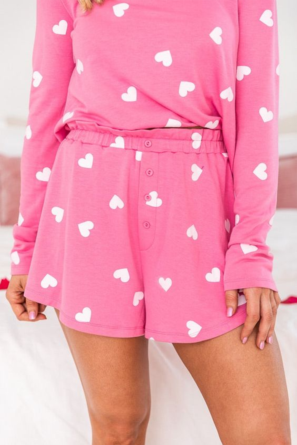 Pink shorts with heart to print design, featuring a comfortable elastic waistband and button closure