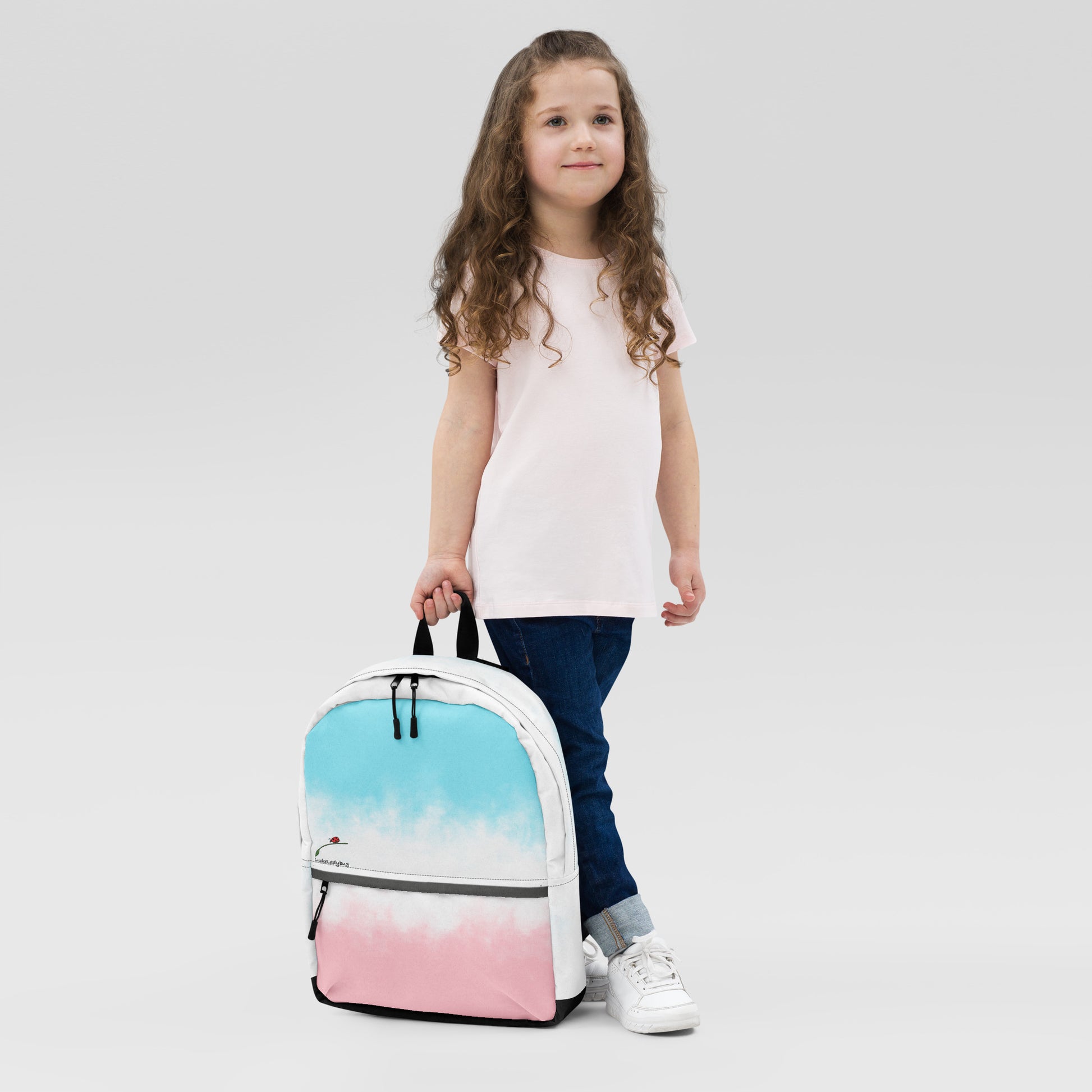 LuckeLadybug pastel tie dye bag for students in blue and pink held by young girl wearing casual clothes
