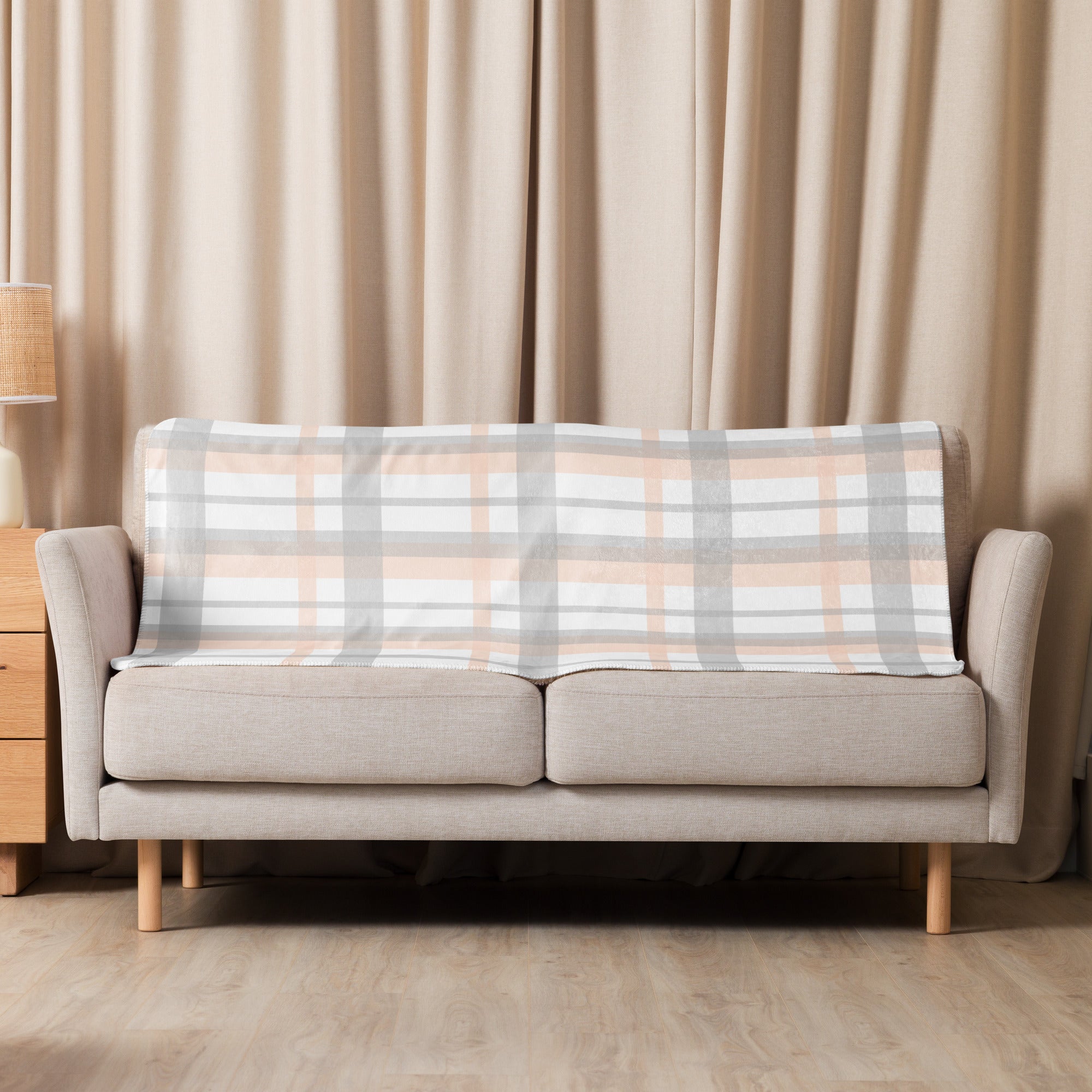 LuckeLadybug peach grey plaid sherpa blanket displayed on beige sofa in cozy living room