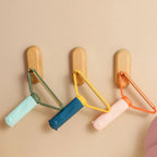Colorful pet flea combs hanging on wooden hooks for easy storage and access