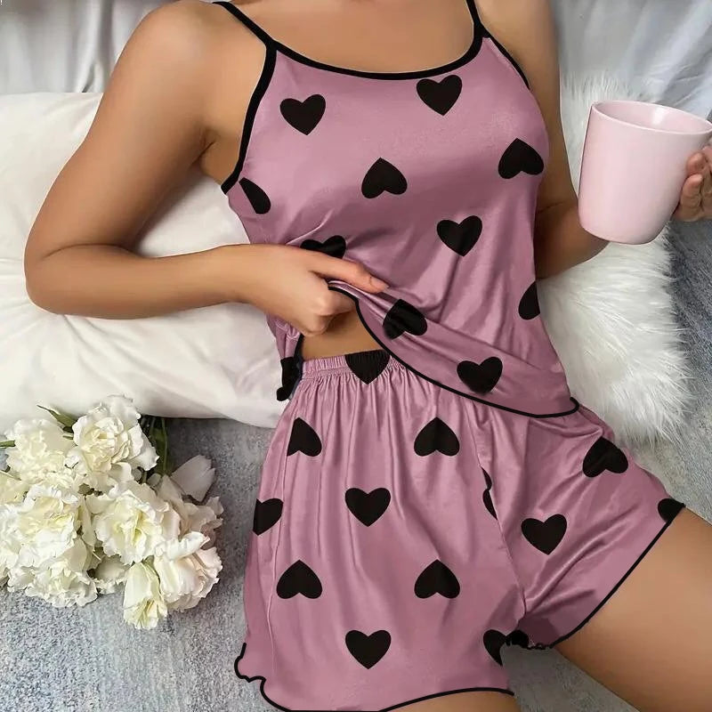 Comfortable pink heart print pajama set with black hearts, perfect for lounging or sleeping