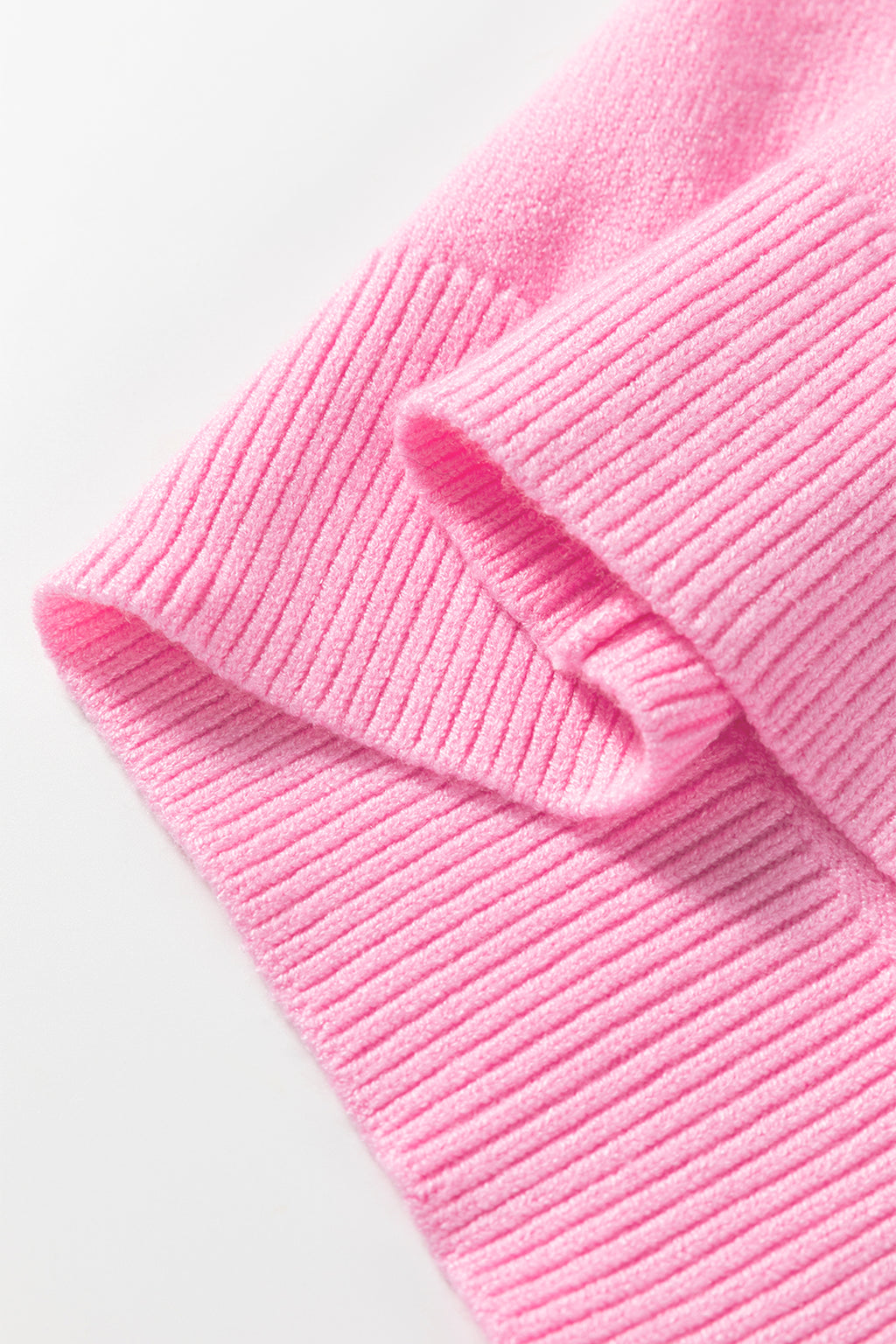 Close-up of a ribbed pink sweater featuring warm fabric, perfect for cozy winter wear