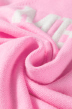 Pink LuckeLadybug white MERRY Christmas sweater fabric detail showing soft texture and cozy feel