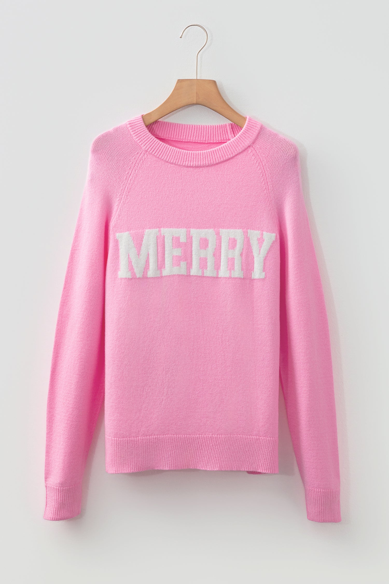 LuckeLadybug pink sweater featuring white MERRY Christmas sweater design for festive style