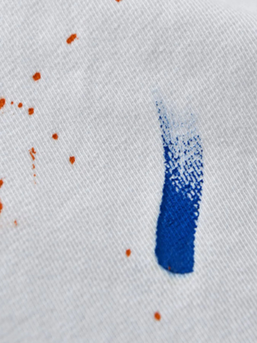 Detail of fabric showing paint splatter on a button-up shirt, perfect for plus size clothing for women's style