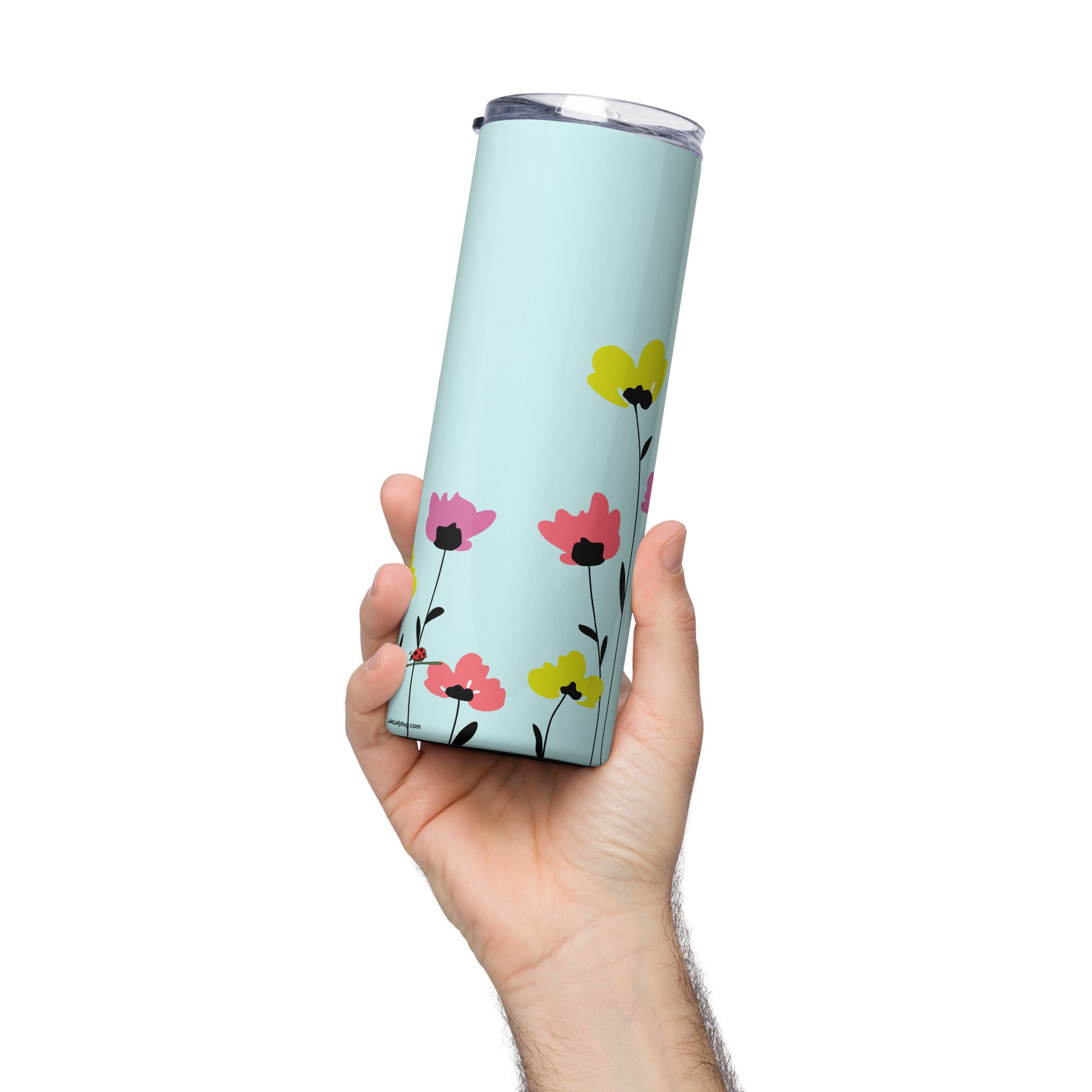 Pretty floral tumbler with straw in blue stainless steel held in hand featuring colorful flower design