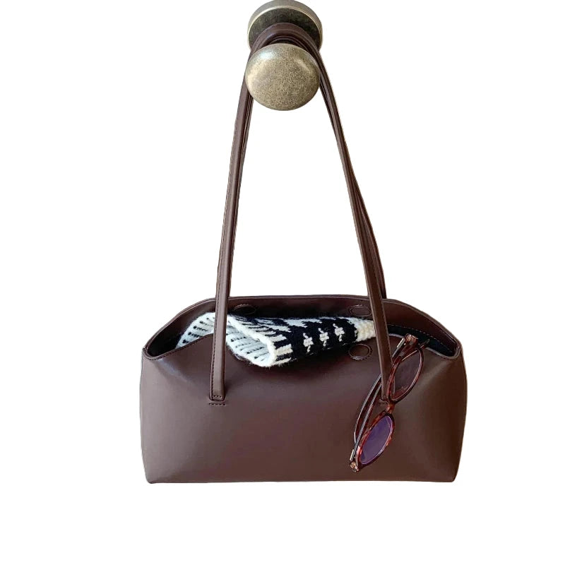 Stylish PU baguette shoulder bag for women in brown with sunglasses and a scarf on a door handle