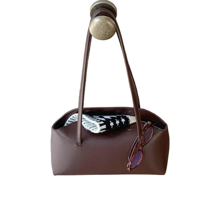 Stylish PU baguette shoulder bag for women in brown with sunglasses and a scarf on a door handle