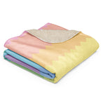 Folded LuckeLadybug rainbow pride sherpa blanket with soft pastel colors and plush lining