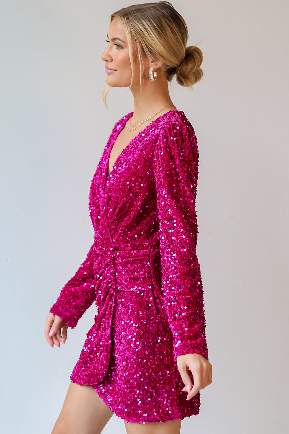 Bright pink dress covered in sequin for dress with a flattering wrap design and long sleeves