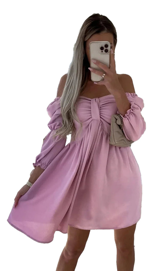 Woman wearing a sexy off shoulder mini dress in pink with a bow detail, ideal for casual outings