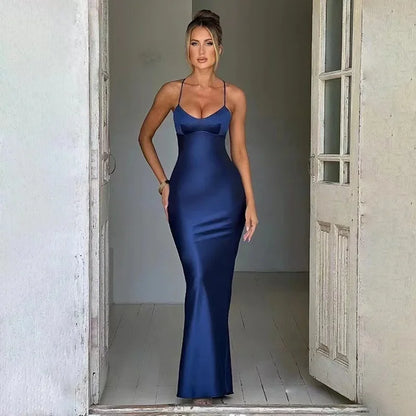 Elegant woman in a navy sexy satin evening gown with spaghetti straps and a fitted silhouette
