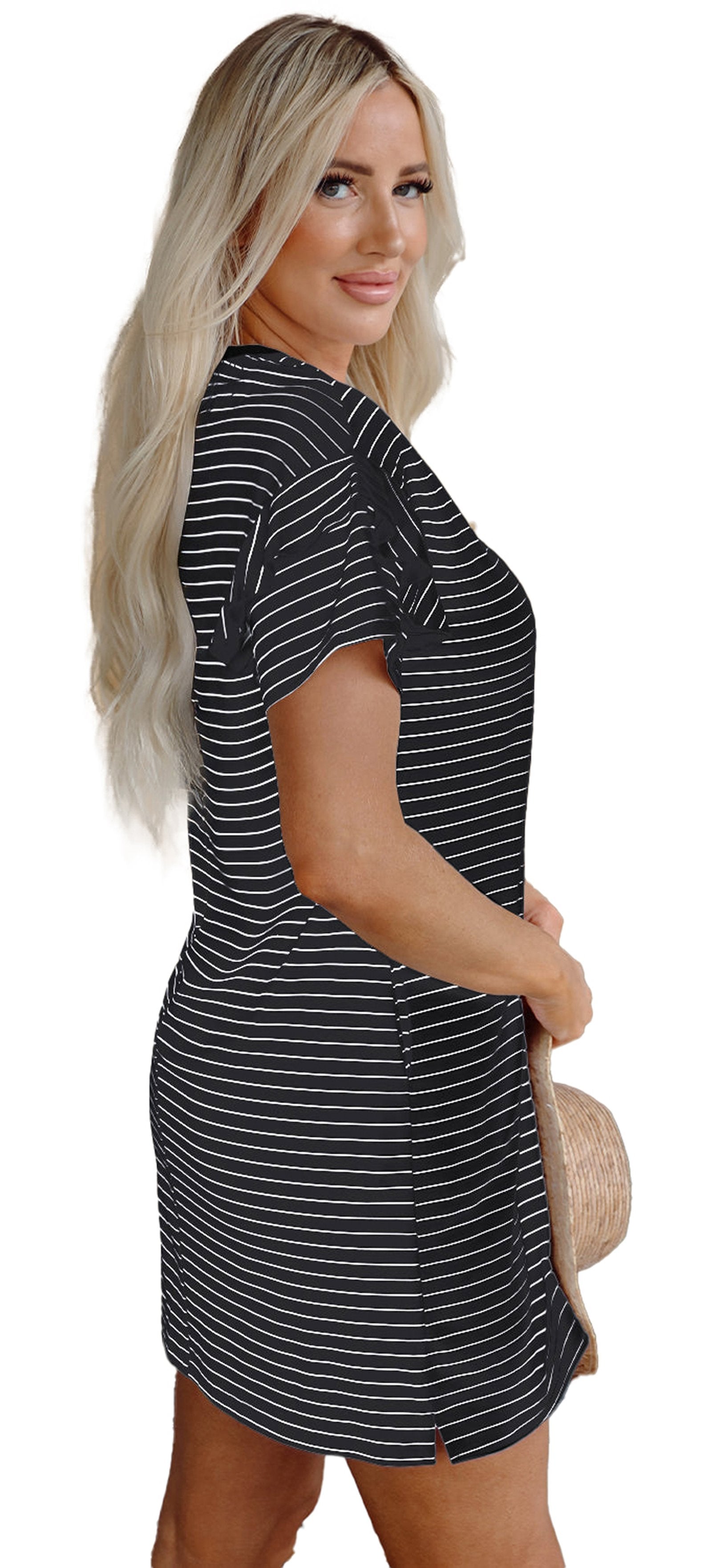 Model in LuckeLadybug black stripe ruffle mini dress side view holding straw hat by front door