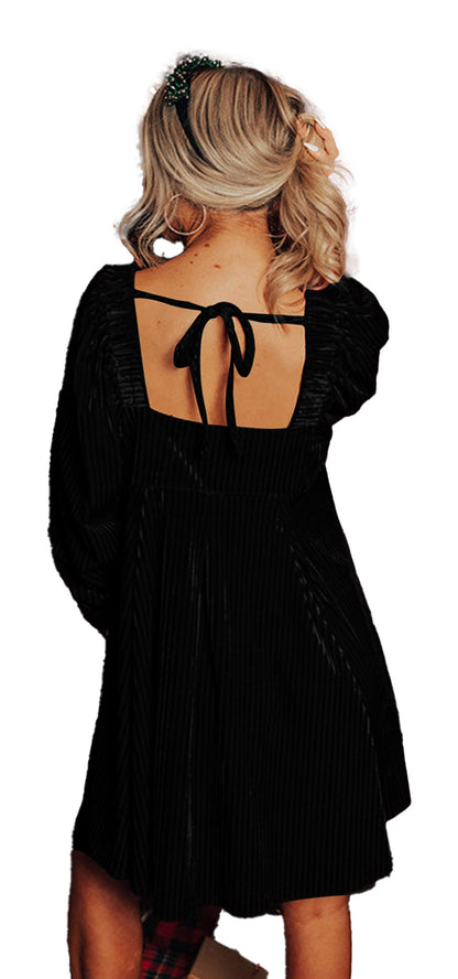 Back view of woman in LuckeLadybug black velvet babydoll dress with square open back bow and puff sleeves