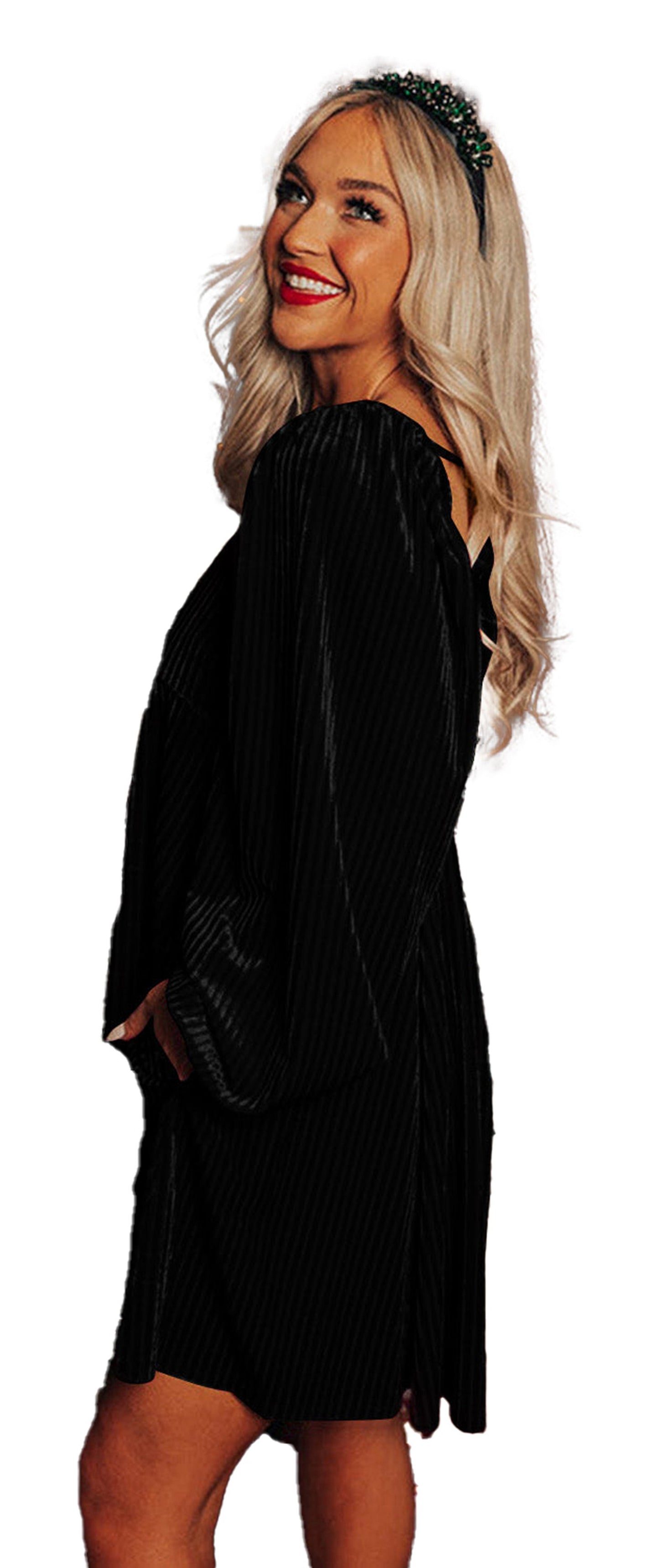 LuckeLadybug model wearing a black velvet babydoll dress with long sleeves beside decorated Christmas tree