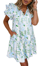Woman wearing a sky blue floral mini dress with ruffled sleeves V neck pockets and tiered hem