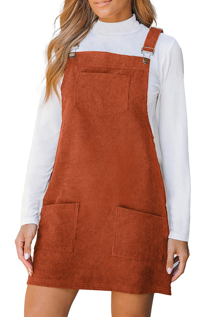 LuckeLadybug vineyard green corduroy overall dress with adjustable straps and front pockets shown in rust over white turtleneck
