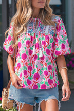 Bright floral short sleeve women blouse from LuckeLadybug LLC with tassel details and a relaxed fit