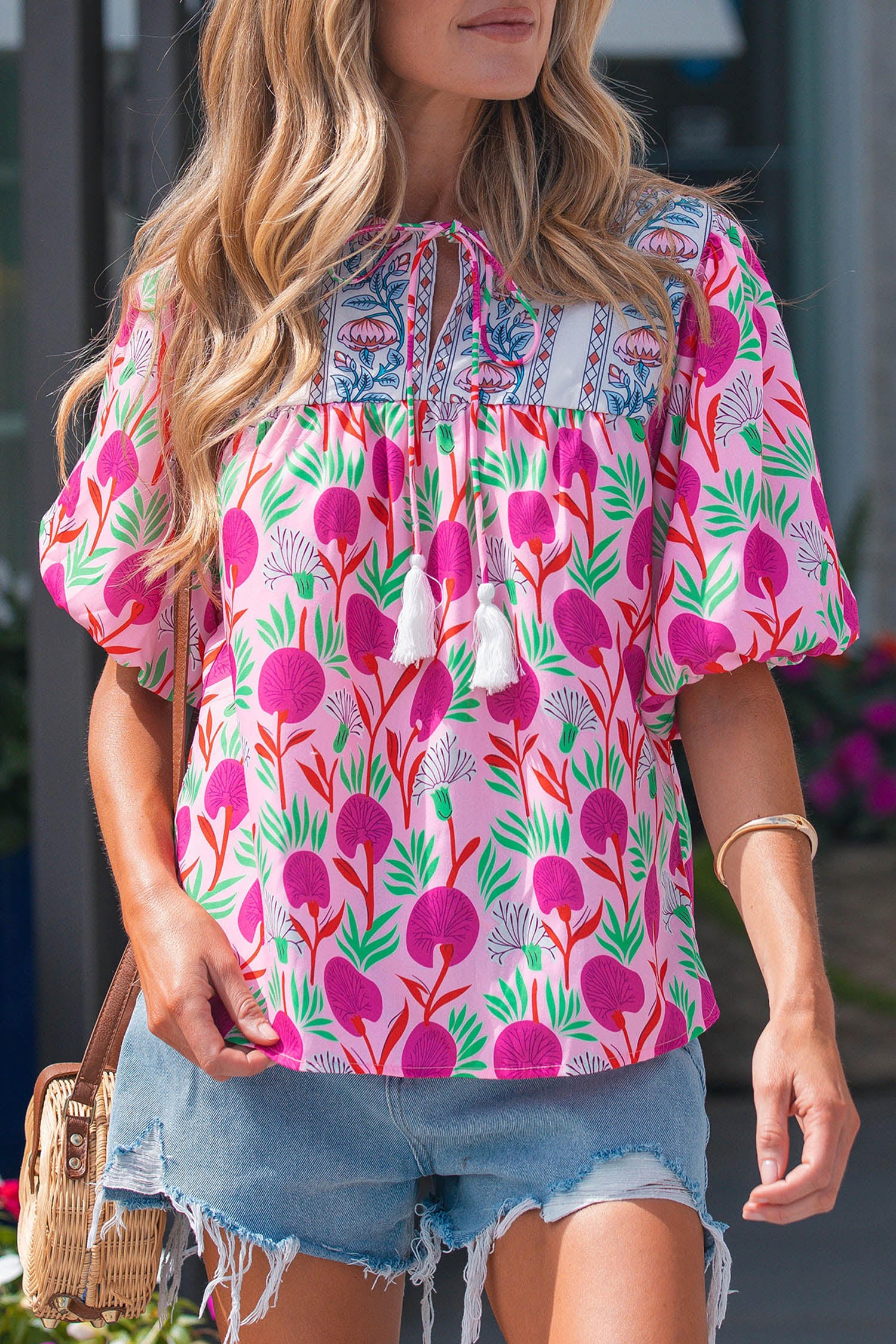 Bright floral short sleeve women blouse from LuckeLadybug LLC with tassel details and a relaxed fit