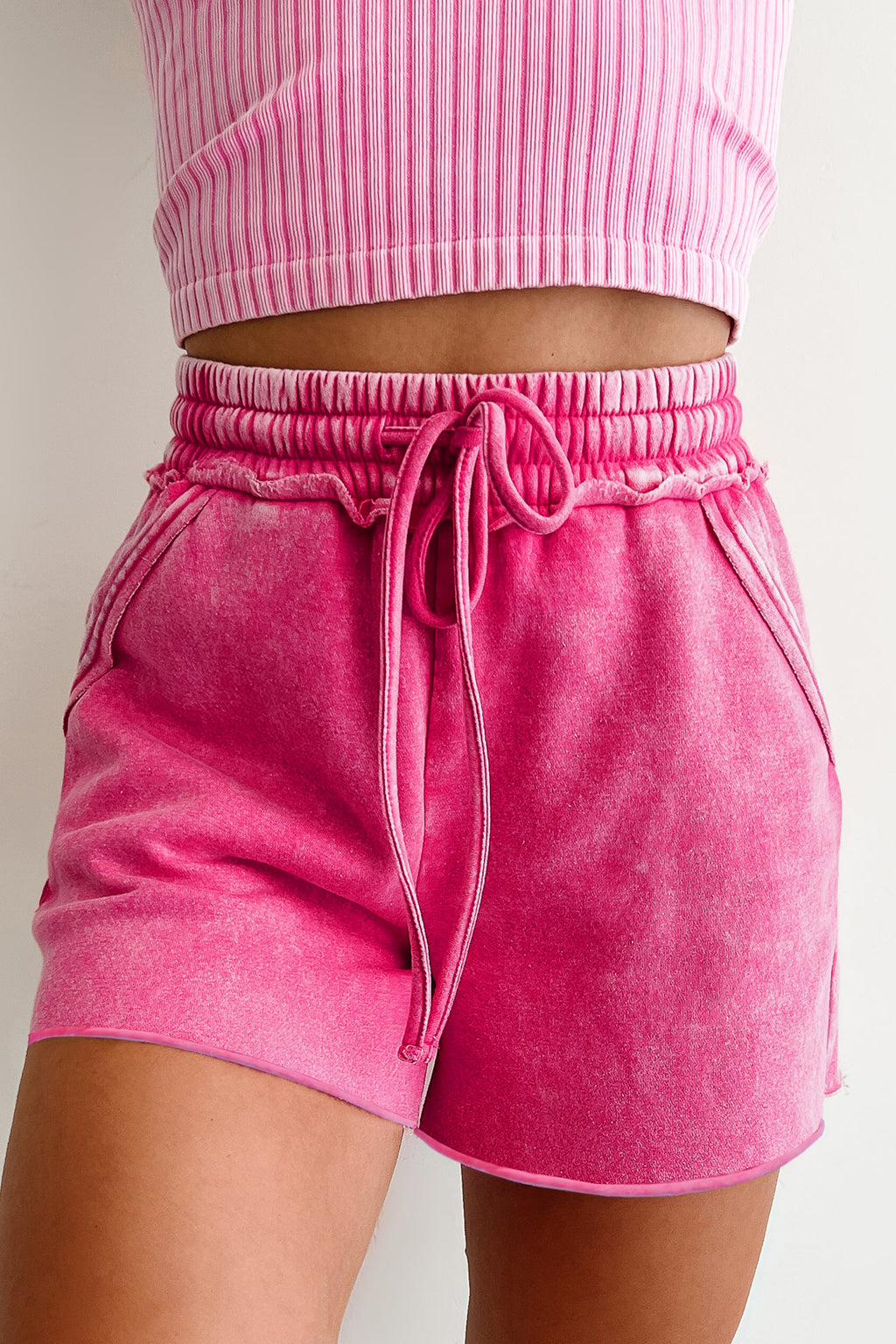 Pink drawstring shorts with a relaxed fit and side pockets for casual summer style