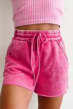 Pink drawstring shorts with a relaxed fit and side pockets for casual summer style