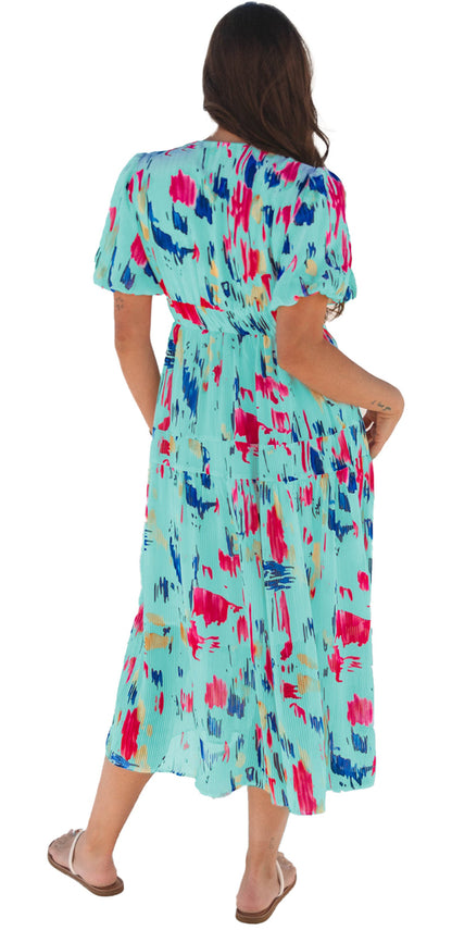 Back view of a woman wearing a sky blue abstract maxi dress with colorful patterns