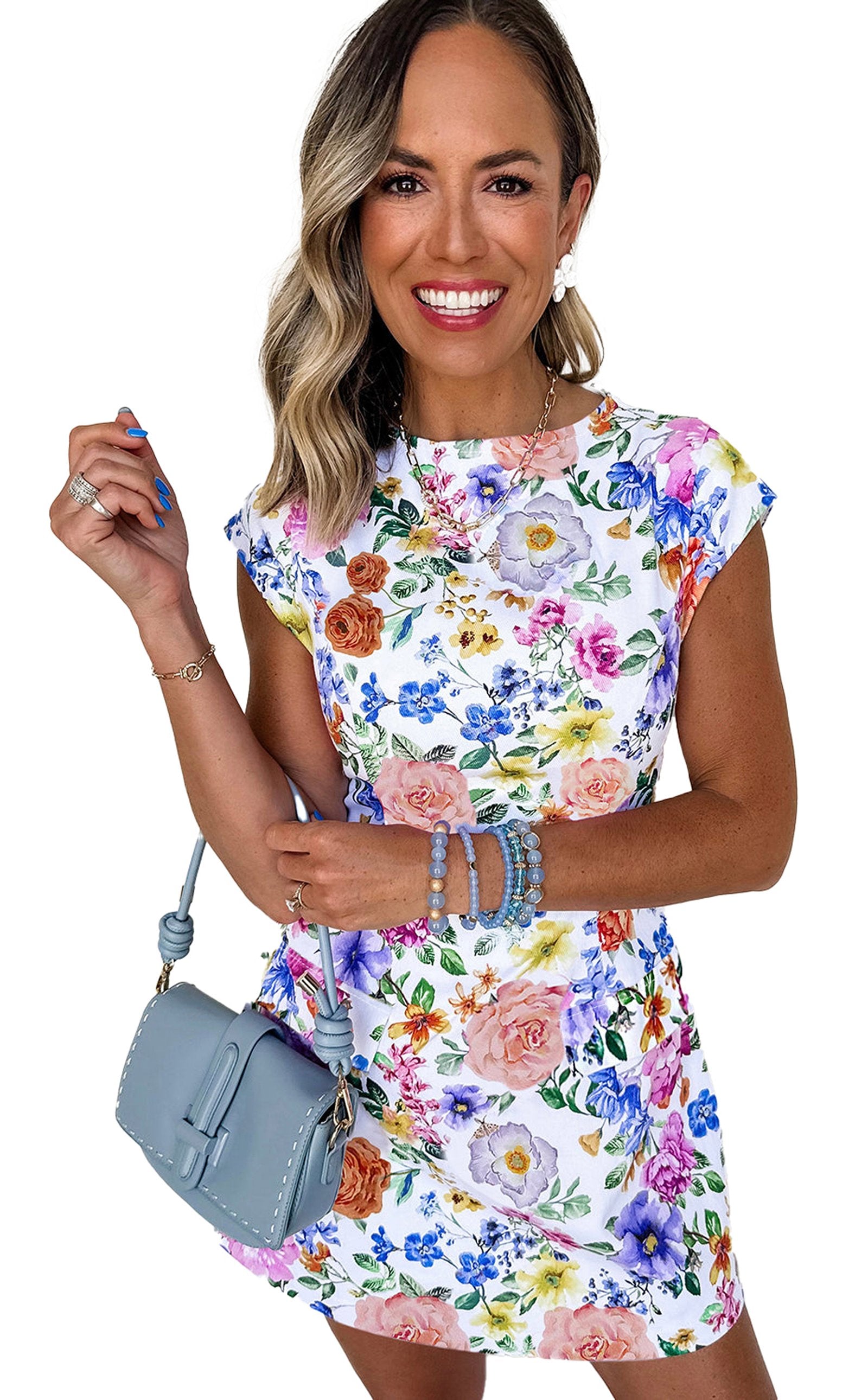 Model wearing a sky blue floral mini dress with vibrant flowers and a stylish handbag