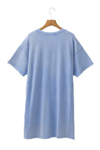 Sky blue t shirt dress by LuckeLadybug LLC hanging on wooden hanger with short sleeves and relaxed fit