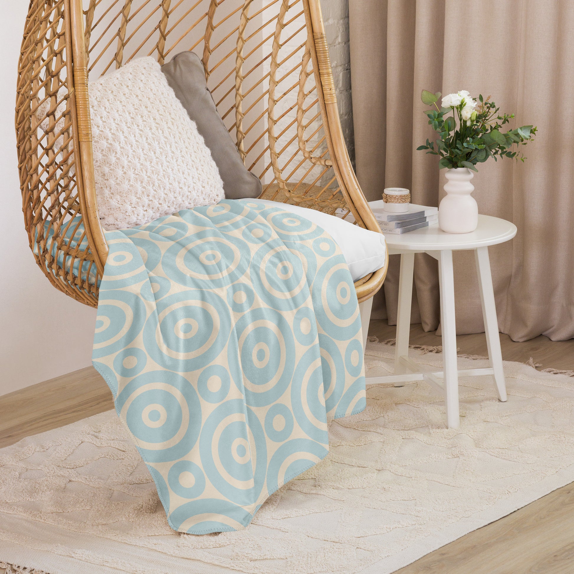 LuckeLadybug soft circle design throw blanket draped over a hanging wicker chair with cushions