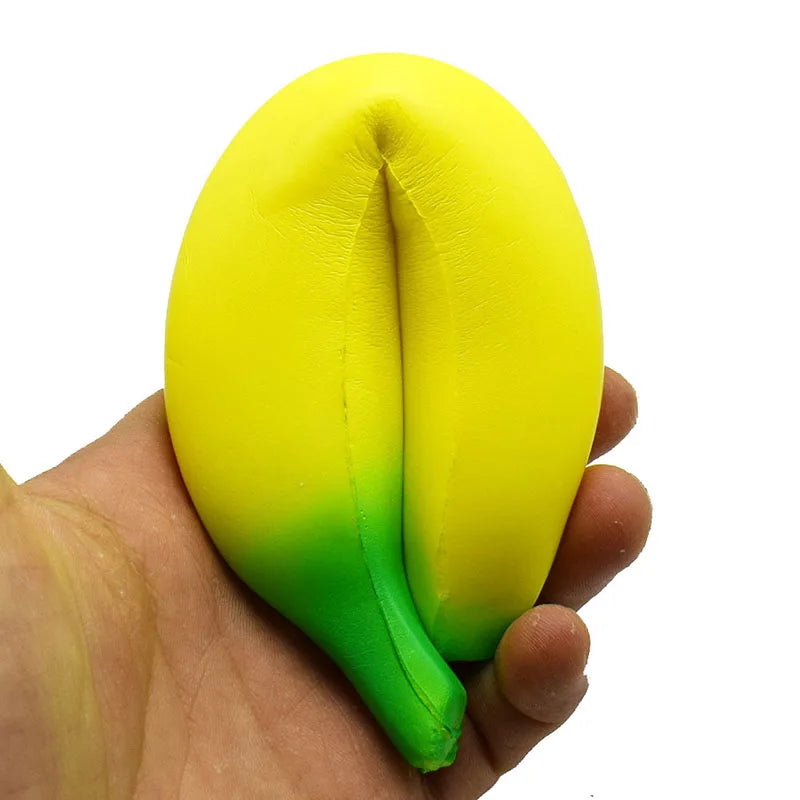 Yellow and green squishy toy shaped like a fruit, held in a person's hand for stress relief