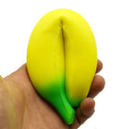 Yellow and green squishy toy shaped like a fruit, held in a person's hand for stress relief