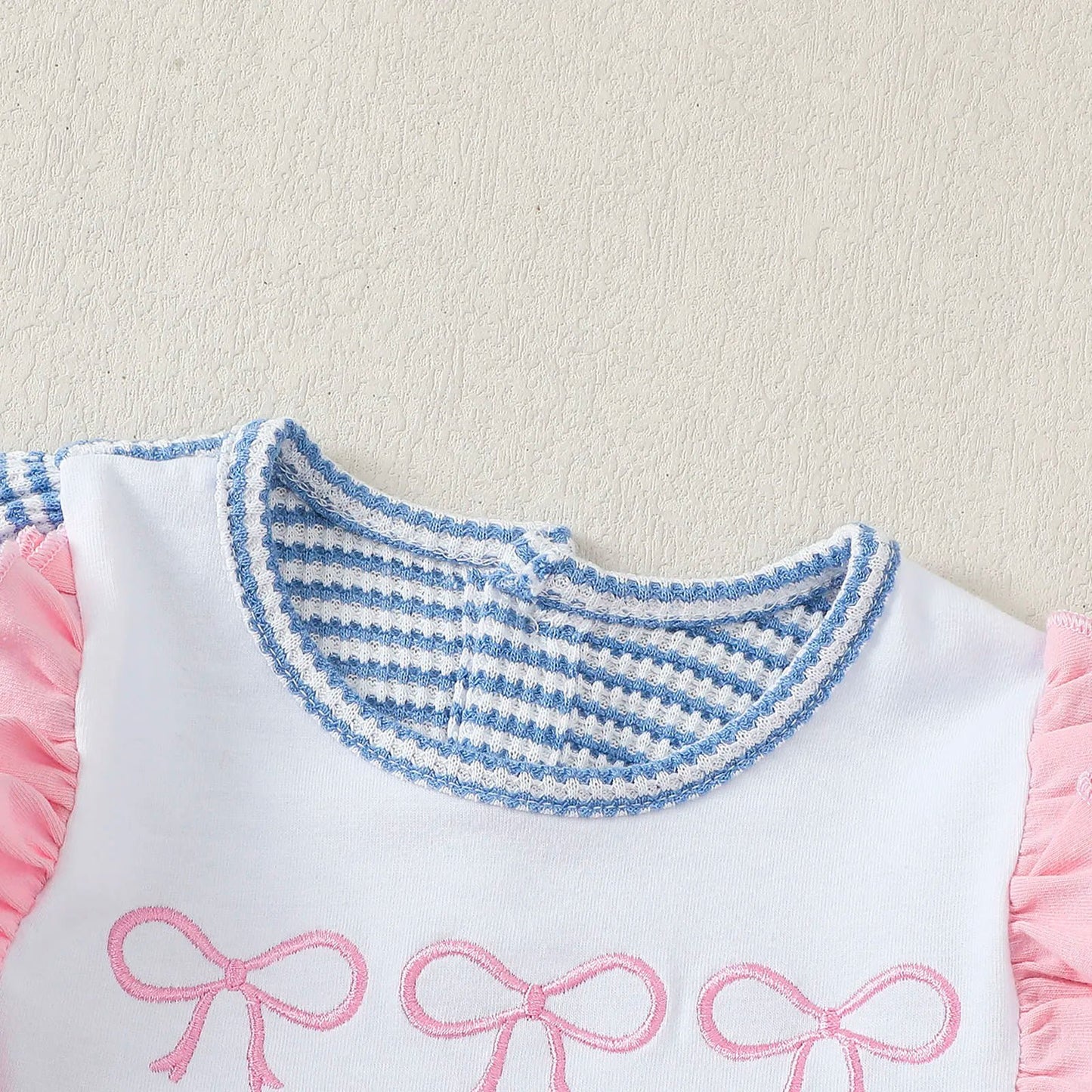 Striped long sleeve baby bodysuit with pink ruffle sleeves and decorative bows for infants