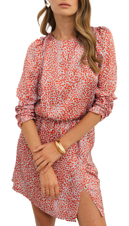 Model wearing red leopard print mini dress with long sleeves side slit cinched waist and gold tone jewelry