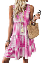 Woman wearing pink and white striped sleeveless mini dress holding straw bag for LuckeLadybug black striped mini dress listing