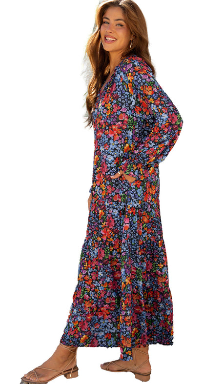 LuckeLadybug blue floral maxi dress with tassel tie on smiling model with long sleeves and sandals