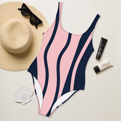 LuckeLadybug pink and navy striped elegant one-piece swimsuit for women styled with straw hat sunglasses and sunscreen
