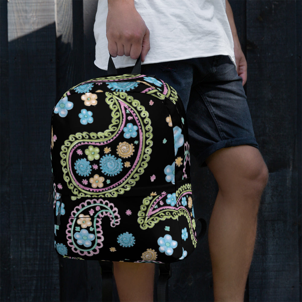 LuckeLadybug trendy paisley print backpack with colorful floral patterns held by person in white shirt and black shorts